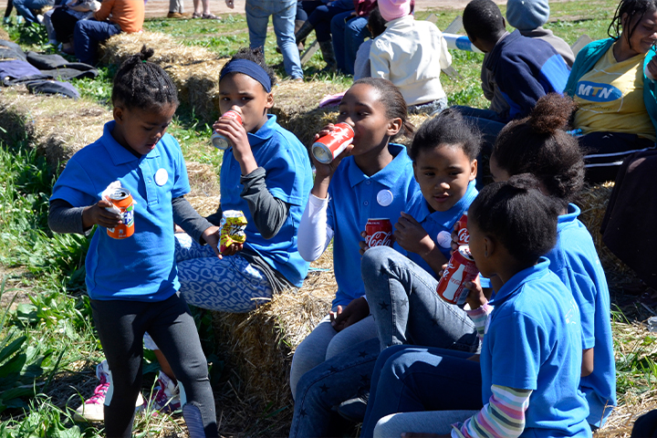 Students at an EQuivalence community event in Durbanville enjoying cold drinks and smiling together during a break.